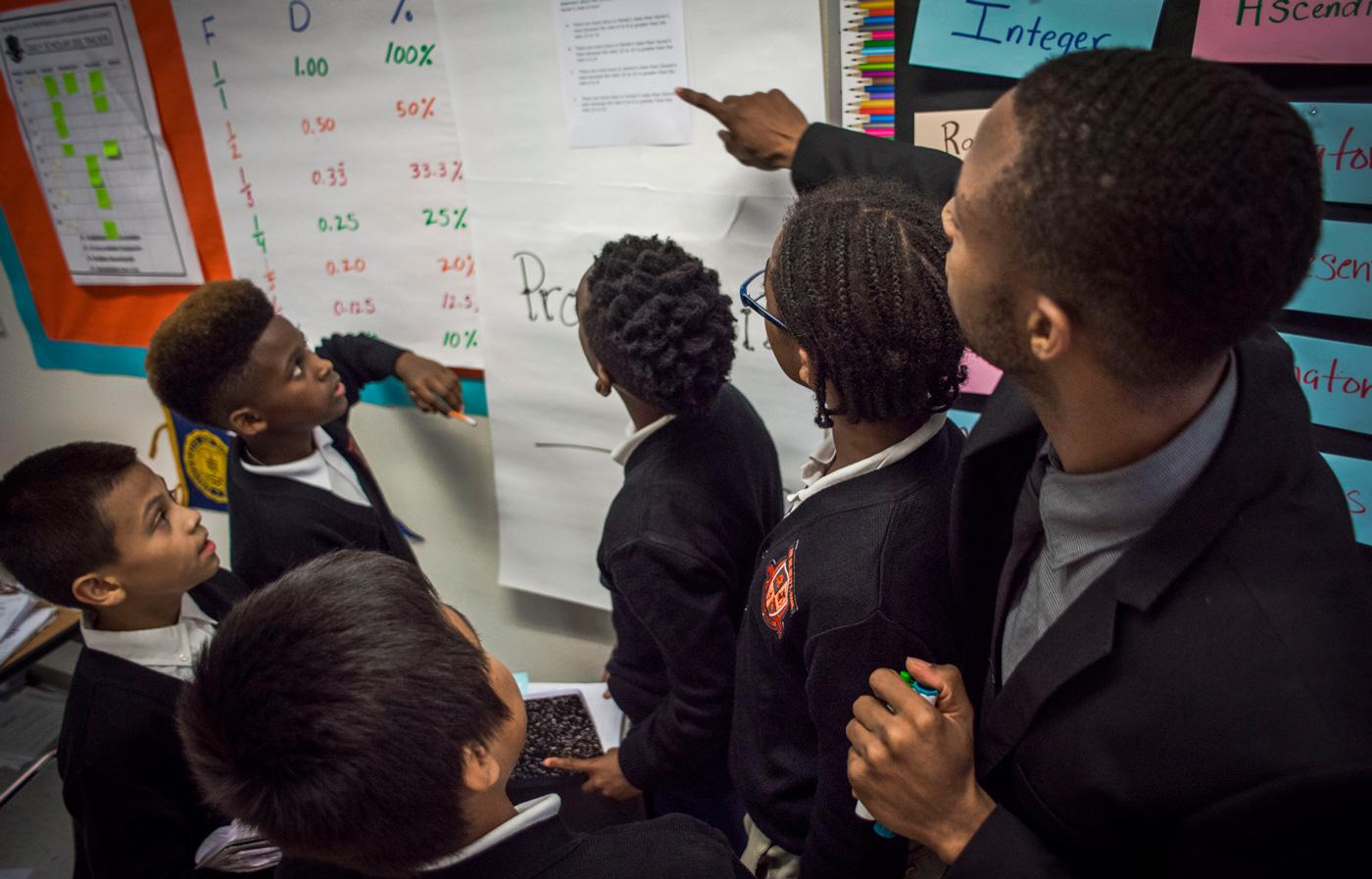 Male teacher showing students information on a whiteboard